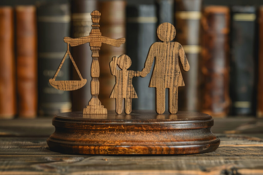 Mother and child standing on a gavel with a scale of justice